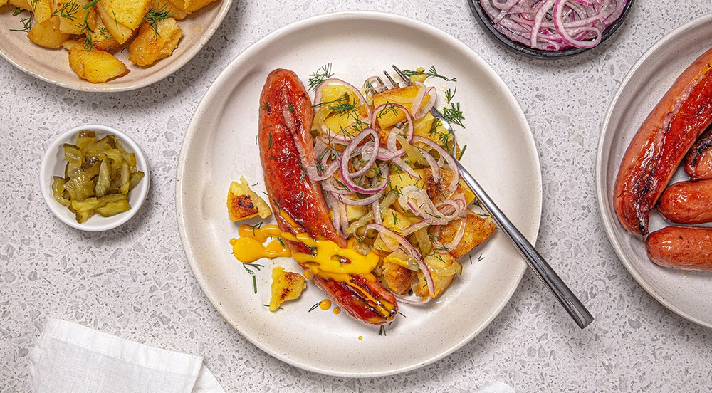 Stekte pølser med knuste mandelpoteter og syltet rødløk