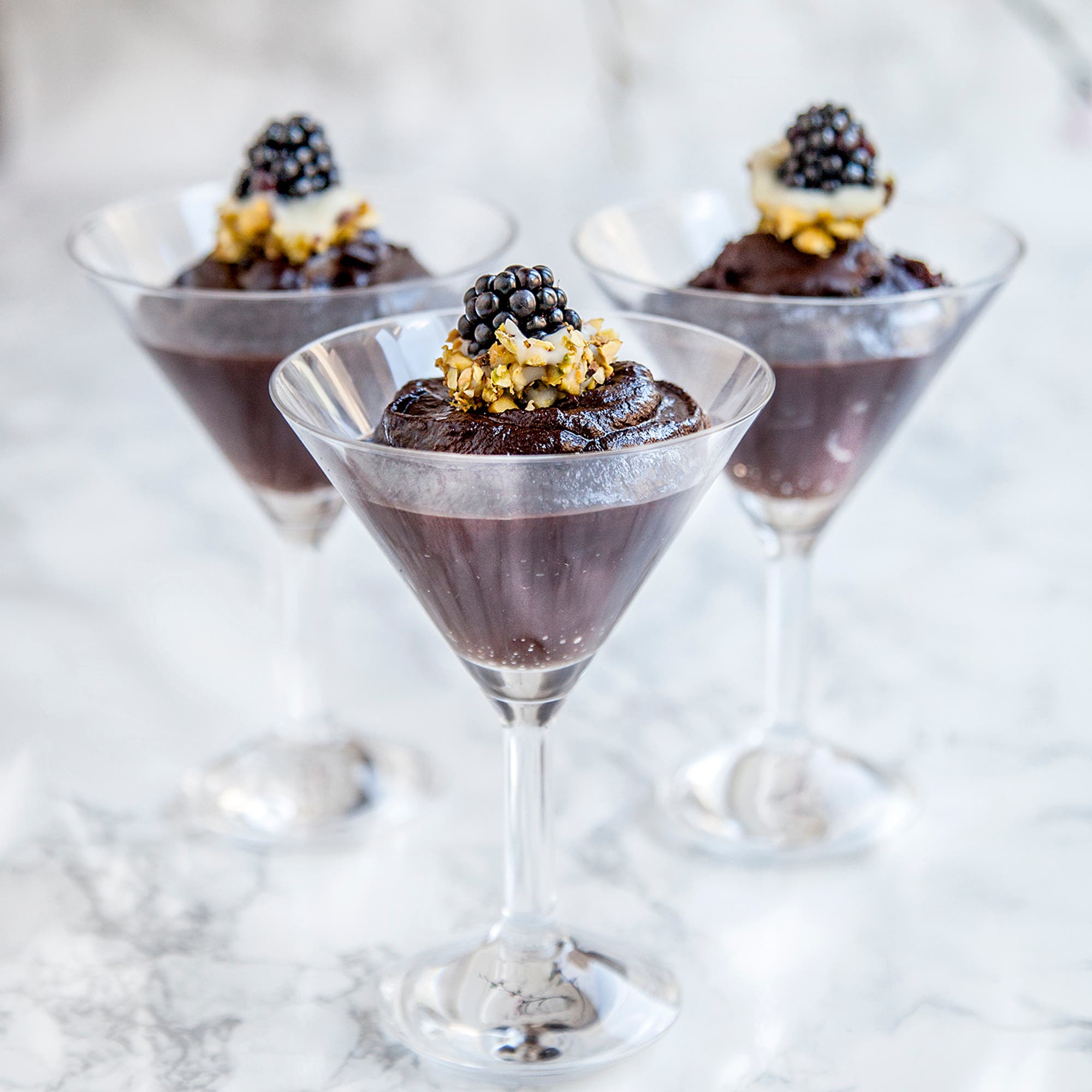 Chokladcrème med björnbär doppade i vit choklad och pistage