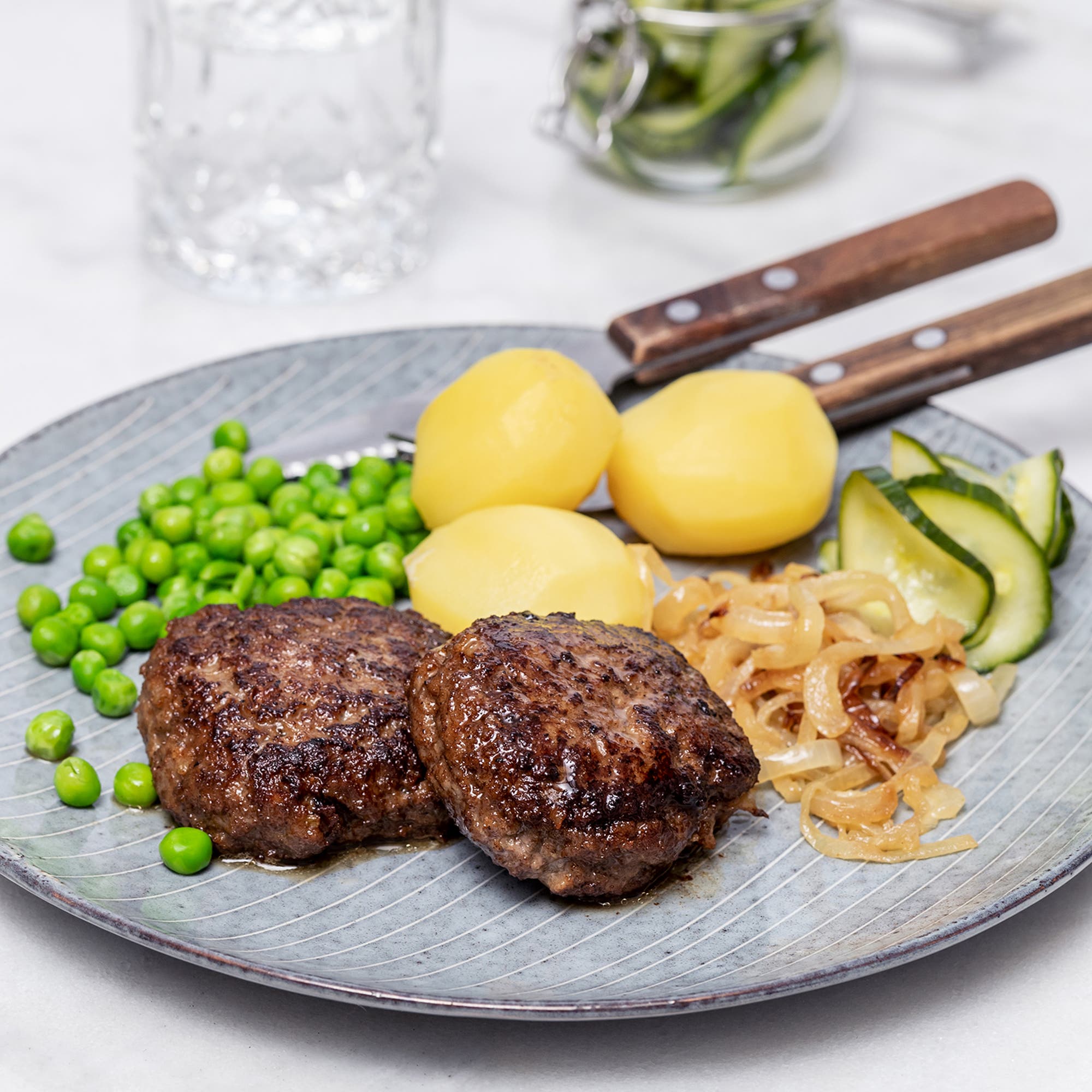 Pannbiff med stekt lök, ättiksgurka och ärtor