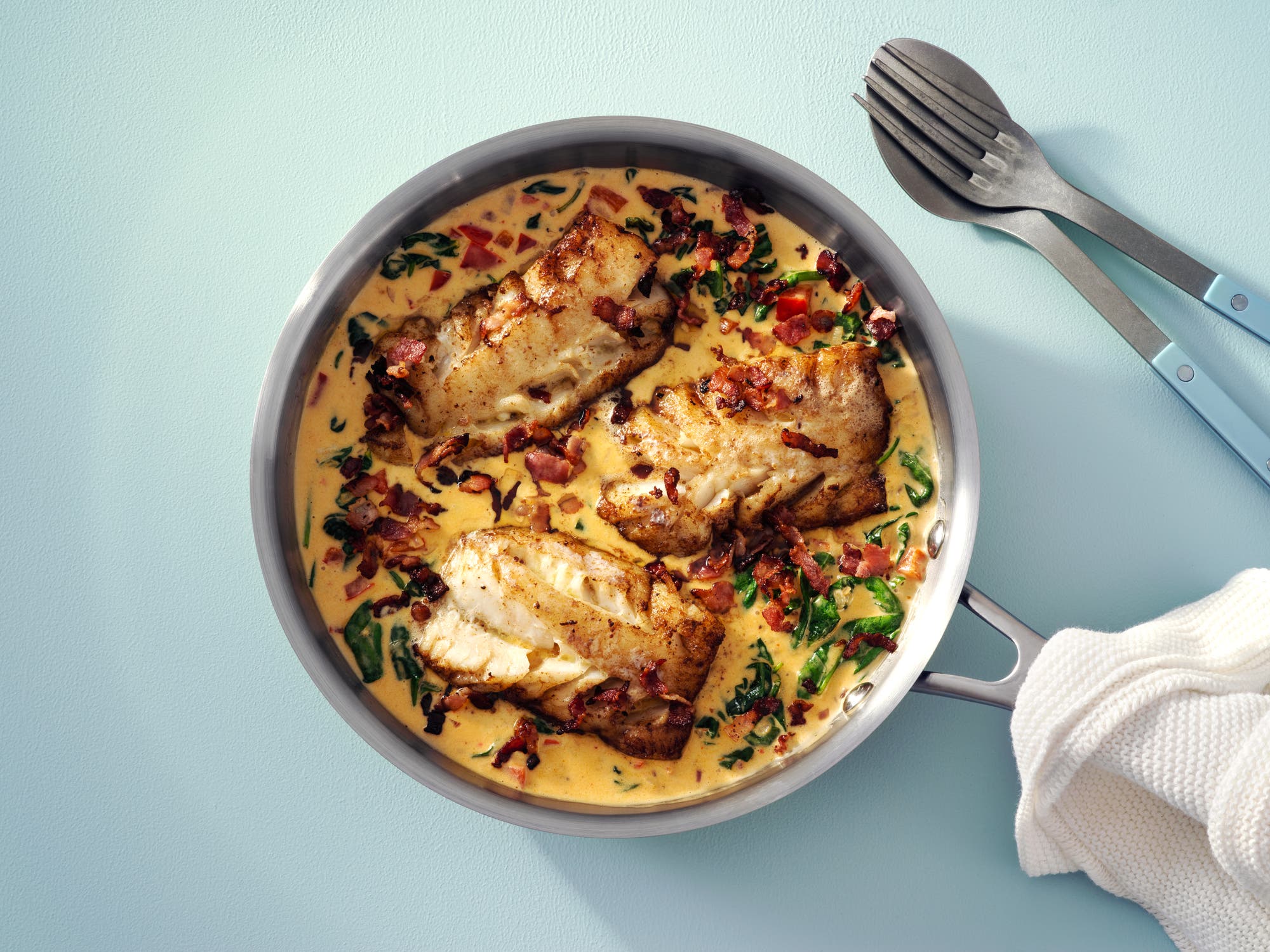 Torskrygg på krämig spenatbädd med knaperstekt bacon