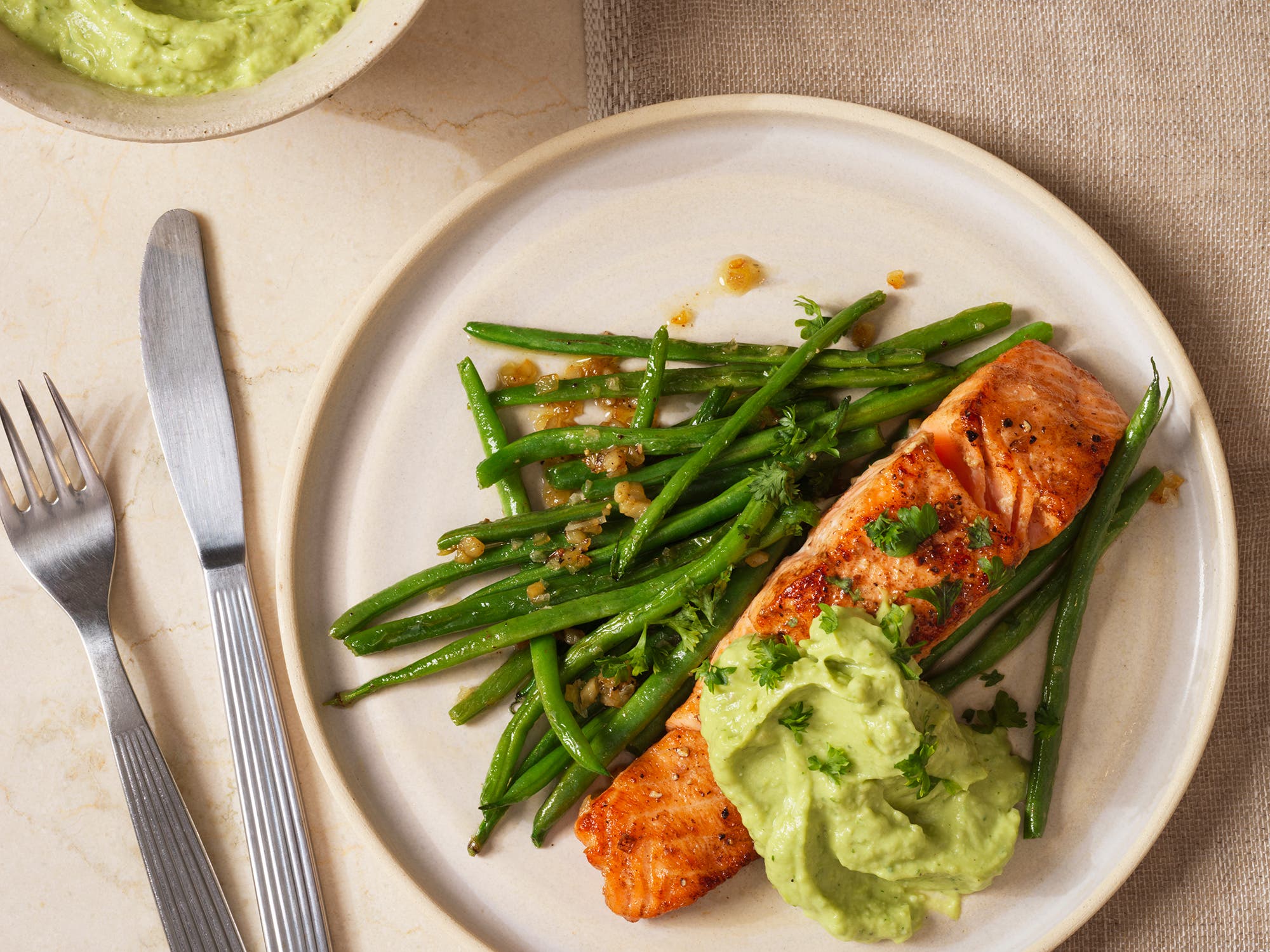 Ovnsbakt laks med avokadokrem og hvitløksstekte bønner