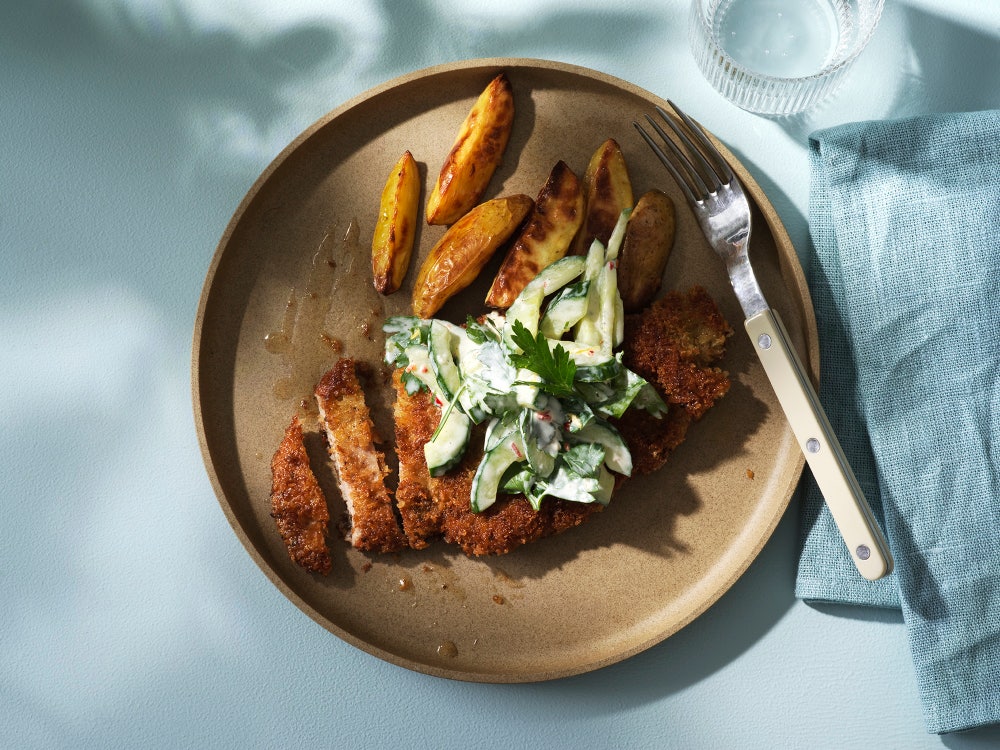 Sprø schnitzel med kremet agurksalat og båtpoteter